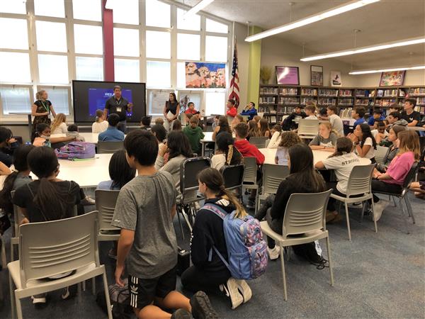 Large group of students in a town hall meeting.